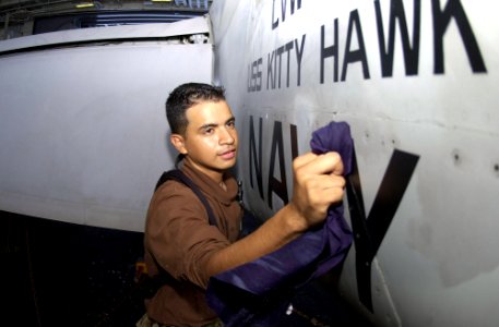 US Navy 040805-N-3488C-005 Airman Rigoberto Vargas from Miami, Fl. cleans an engine door on an F-A-18F Super Hornet aboard the aircraft carrier USS Kitty Hawk (CV 63)