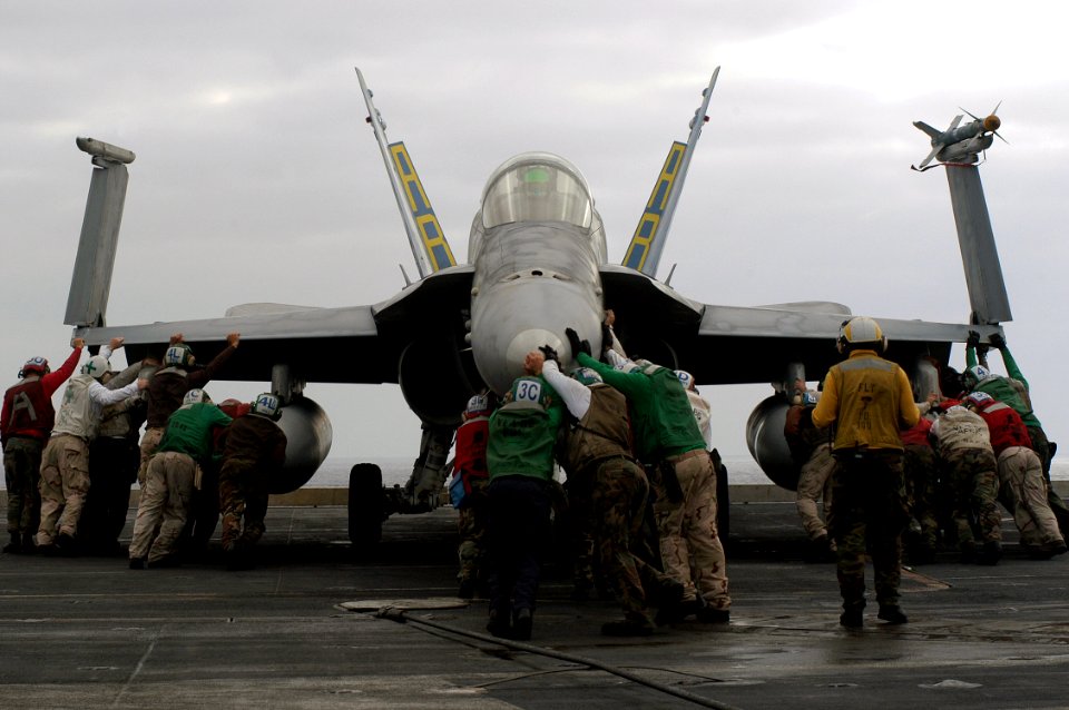 US Navy 040714-N-9742R-044 Flight deck personnel push back an F-A-18 Hornet, assigned to the Marauders of Strike Fighter Eight Two (VFA-82)