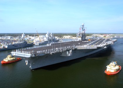US Navy 040607-N-8704K-003 Two harbor tugs guide the USS John F. Kennedy (CV 67) out of Naval Station Mayport harbor