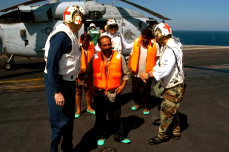 US Navy 040814-N-8704K-010 Aboard USS John F. Kennedy (CV 67), crew members including medical personnel assist Iranian mariners off an HH-60H Seahawk belonging to the Red Lions of Helicopter anti-submarine Squadron Fifteen (HS