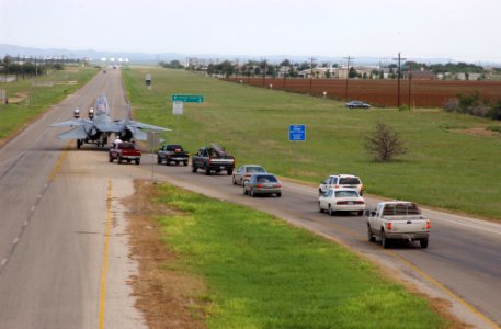 US Navy 040813-F-0017M-004 A line of cars follow the decommissioned F-14A Tomcat while it is towed from San Angelo Regional Airport to Goodfellow Air Force Base, Texas
