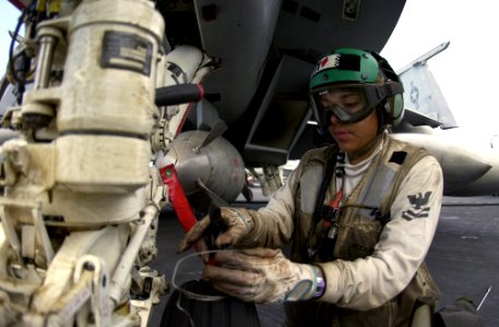 US Navy 040805-N-3488C-003 Aviation Structural Mechanic 2nd Class Iriana Ciseneros from Santa Cruz, CA repairs safety wire on the nose landing gear of an F-A-18F Super Hornet aboard USS Kitty Hawk (CV 63)