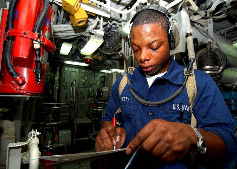 US Navy 040731-N-4374S-010 Fireman Apprentice Marquis Petty monitors the engine gauges in the main machinery room aboard the mine countermeasure ship USS Dextrous (MCM 13)