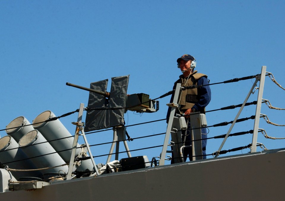 US Navy 040625-N-0780F-007 A Sailor assigned to the guided missile destroyer USS Ramage (DDG 61), stands a top-side security watch as the ship prepares to get underway following a brief port visit