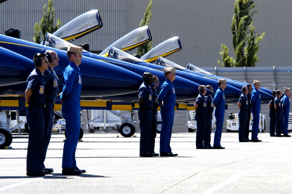 US Navy 040805-N-6477M-190 Pilots and Maintenance Personnel assigned to the Blue Angels Maintenance and Support Team stand at parade rest in front of their F-A-18 Hornets