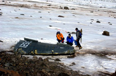 US Navy 040809-N-0331L-003 Lt. Cmdr. Christopher Blow, center, examines the wreckage of a Navy P-2V Neptune aircraft that crashed over Greenland in 1962