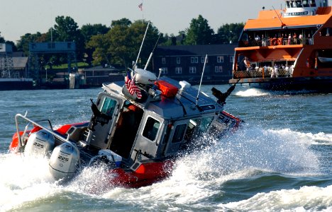 US Navy 040901-C-4938N-085 A 25-foot Defender Class security boat attached to the Coast Guard Maritime Safety and Security Team 91106 sweeps the East River around Whitehall Terminal as the Staten Island Ferry arrives to Manhatt