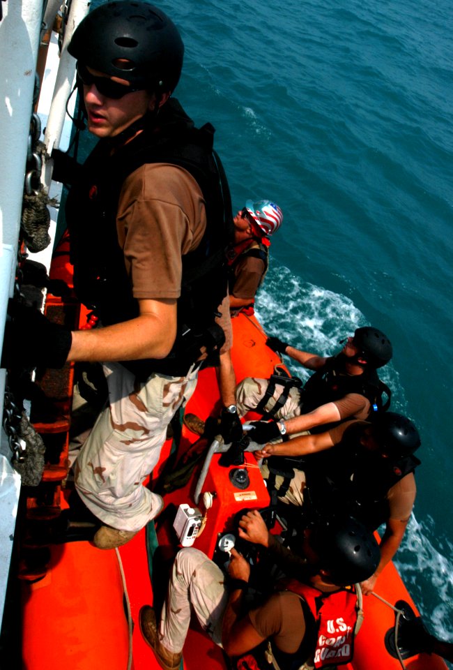 US Navy 040731-G-1034C-014 Boatswain's Mate 2nd Class Petty Officer Mason Frantom and Boarding Team Member climbs back aboard the U.S. Coast Guard Cutter Adak (WPB 1333), following a routine boarding operation