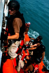 US Navy 040731-G-1034C-014 Boatswain's Mate 2nd Class Petty Officer Mason Frantom and Boarding Team Member climbs back aboard the U.S. Coast Guard Cutter Adak (WPB 1333), following a routine boarding operation