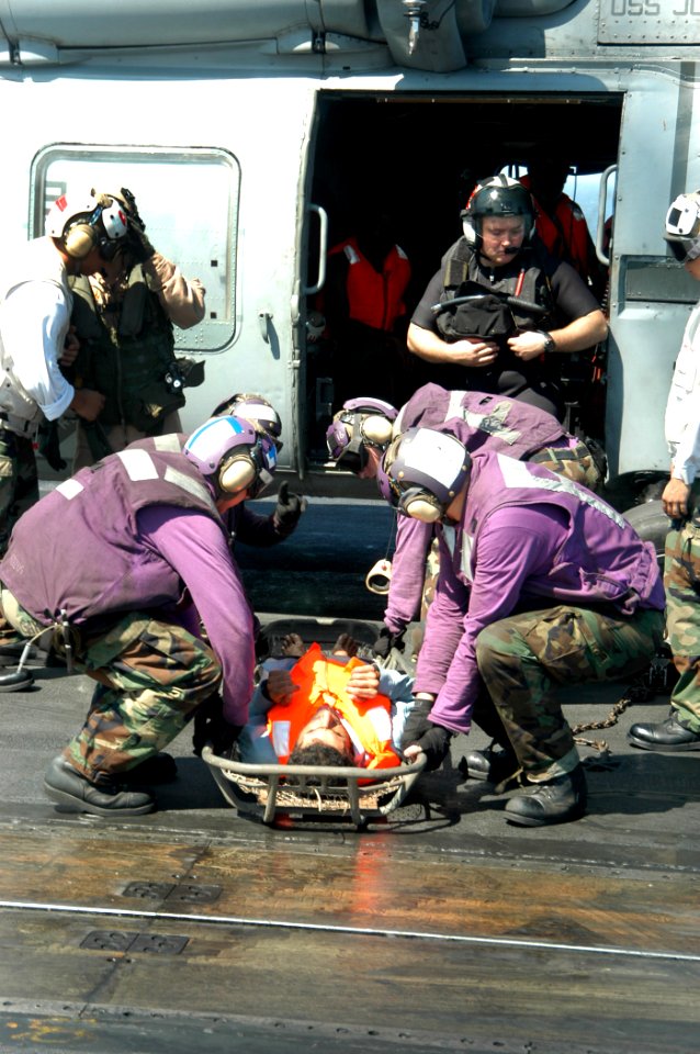 US Navy 040814-N-8704K-007 Aboard USS John F. Kennedy (CV 67), flight deck personnel prepare to carry one of six Iranian mariners by stretcher from an SH-60F Seahawk belonging to the Red Lions of Helicopter anti-submarine Squad