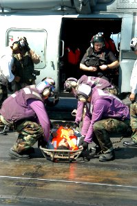 US Navy 040814-N-8704K-007 Aboard USS John F. Kennedy (CV 67), flight deck personnel prepare to carry one of six Iranian mariners by stretcher from an SH-60F Seahawk belonging to the Red Lions of Helicopter anti-submarine Squad