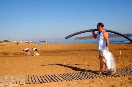 US Navy 040820-N-0780F-002 Utilitiesman 1st Class John Gillespie, assigned to U.S. Naval Support Activity Souda Bay, carries trash found on Stalos Beach