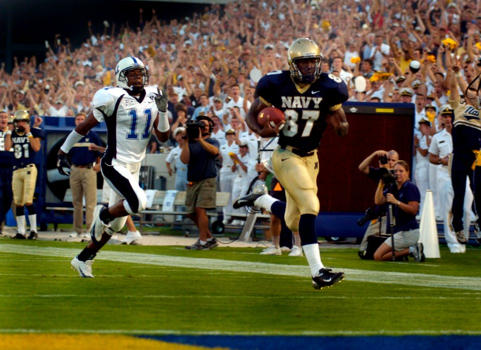 US Navy 040904-N-9693M-005 U.S. Naval Academy Midshipman 3rd Class Jason Tomlinson runs 58-yards on a pass from Quarterback Aaron Polanco for a touchdown, with Duke's John Talley in pursuit