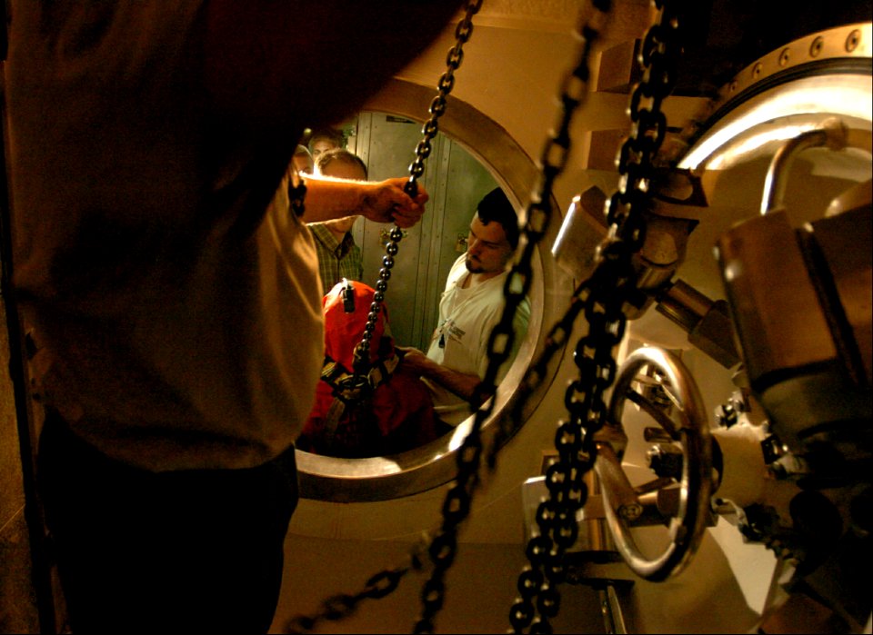 US Navy 040821-N-2653P-018 General Dynamics Electric Boat test engineers, Glen Colechia, Jason Hartle, and Matt Derosier place a Submarine Escape Immersion Equipment (SEIE) test mannequin in the lock-out truck aboard PCU Virgin