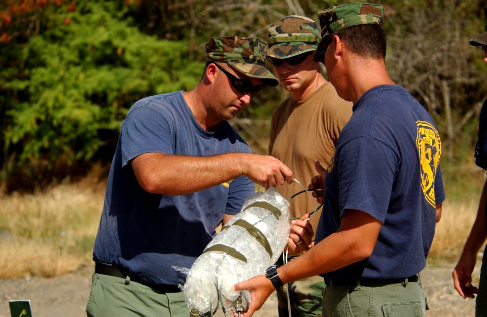 US Navy 040709-N-6811L-120 Members of Mobile Diving Salvage Unit One (MDSU 1) assemble a dual watering firing device for an underwater demolition training exercise