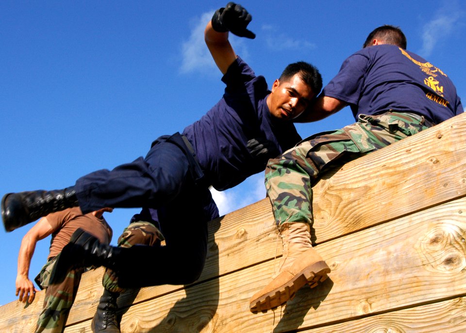 US Navy 040820-N-3019M-001 - A chief petty officer (CPO) selectee scales a wall with the help of his teammates at the Fleet Marine Force (FMF) Challenge