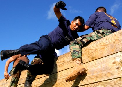 US Navy 040820-N-3019M-001 - A chief petty officer (CPO) selectee scales a wall with the help of his teammates at the Fleet Marine Force (FMF) Challenge