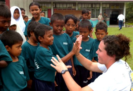 US Navy 040714-N-4104L-005 Lt. j. g. Sarah Heidt, anti-submarine warfare officer on board USS McCampbell (DDG 85), teaches Aboriginal students at their school how to give a high five photo
