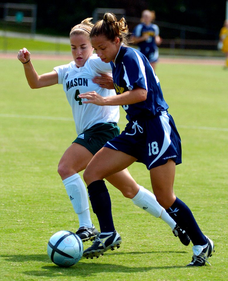 US Navy 040829-N-9694M-002 U.S. Naval Academy Midshipman 3rd Class Meggie Curran races to keep the ball away from George Mason University's Danielle McDonald during a regular season soccer match