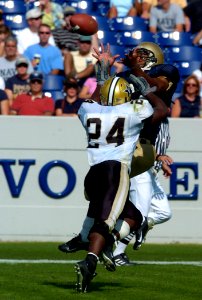 US Navy 040925-N-9693M-010 U.S. Naval Academy Midshipman 1st Class Eric Roberts catches a pass under pressure from Vanderbilt's Marcus Bugss