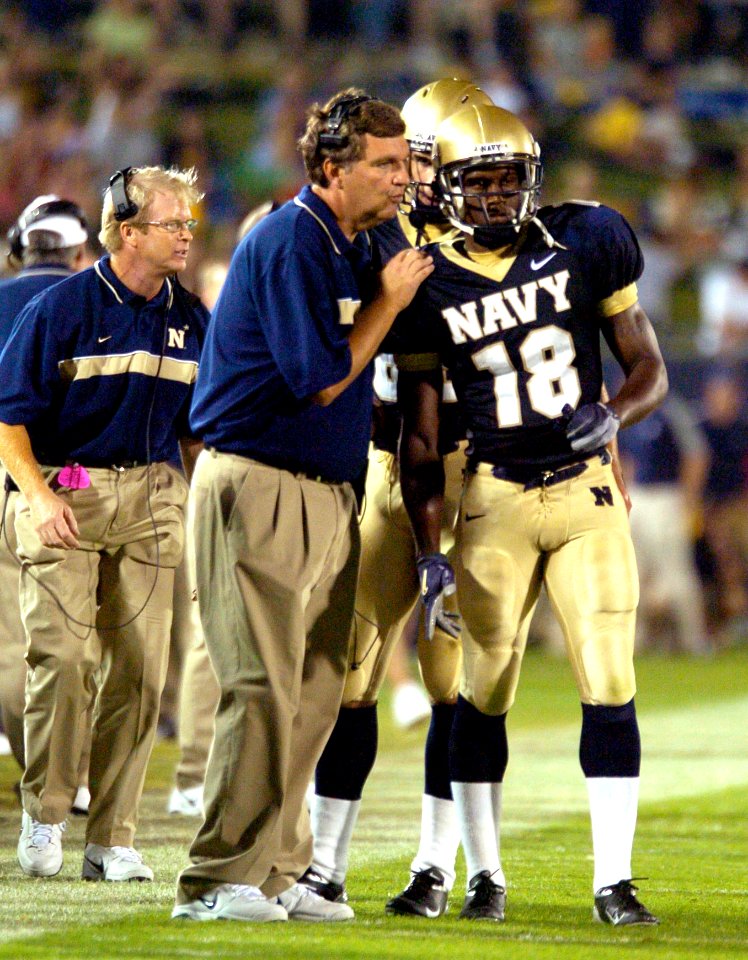 US Navy 040904-N-9693M-010 U.S. Naval Academy football team head coach Paul Johnson sends the teams next play in with Midshipman 1st Class Lionel Wesley