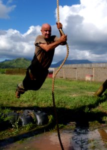 US Navy 040820-N-3019M-009 A chief petty officer (CPO) selectee swings over a water pit at the Fleet Marine Force (FMF) Challenge