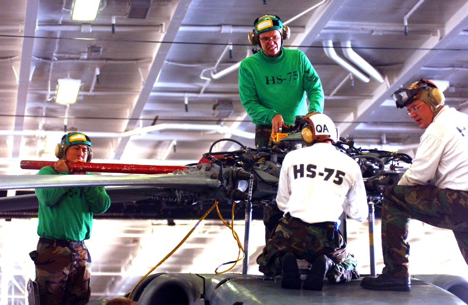 US Navy 040909-N-5345W-090 Sailors assigned to Helicopter Anti-Submarine Squadron Seven Five (HS-75), perform routine maintenance on an SH-60 Seahawk