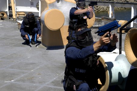 US Navy 040723-N-6477M-129 Sailors assigned to the guided missile destroyer USS Shoup (DDG 86) defend themselves with paint ball guns during a Visit Board Search and Seizure (VBSS) training evolution aboard a decommissioned ves photo