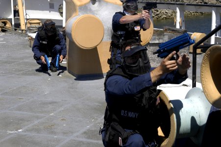 US Navy 040723-N-6477M-129 Sailors assigned to the guided missile destroyer USS Shoup (DDG 86) defend themselves with paint ball guns during a Visit Board Search and Seizure (VBSS) training evolution aboard a decommissioned ves