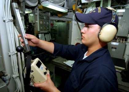 US Navy 040731-N-4374S-007 Fireman Joseph Dever performs a heat index survey in the auxiliary machinery room while standing a sound and security watch aboard the mine countermeasure ship USS Dextrous (MCM 13)