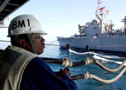 US Navy 040917-N-4374S-004 Boatswain's Mate 1st Class Willie McArthur assigned to the aircraft carrier USS John F. Kennedy (CV 67), observes a replenishment at sea
