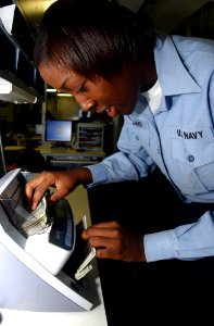 US Navy 041007-N-8158F-018 Disbursing Clerk 3rd Class Lakisha Williams of Memphis, Tenn., completes cash verification using the Magner 75 cash counting machine aboard the aircraft carrier USS Nimitz (CVN 68)