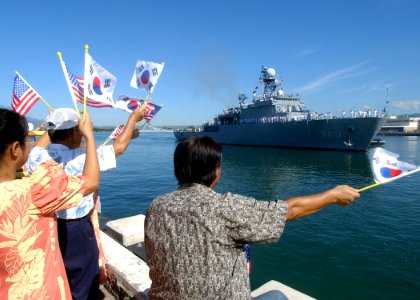 US Navy 041014-N-3019M-003 Family members and guests wave to Sailors aboard the Republic of Korea Ship ROKS Won San (MLS 560) as she enters Pearl Harbor, Hawaii, for a three-day port visit