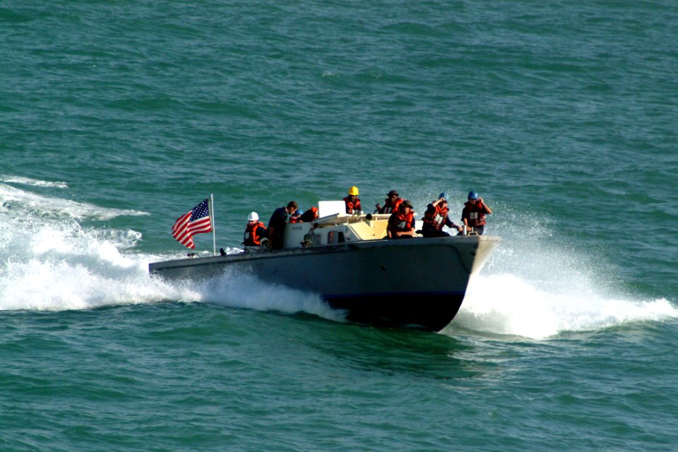 US Navy 040915-N-4772B-001 A small boat attached to the amphibious dock landing ship USS Harpers Ferry (LSD 49) approaches the ship's stern gate