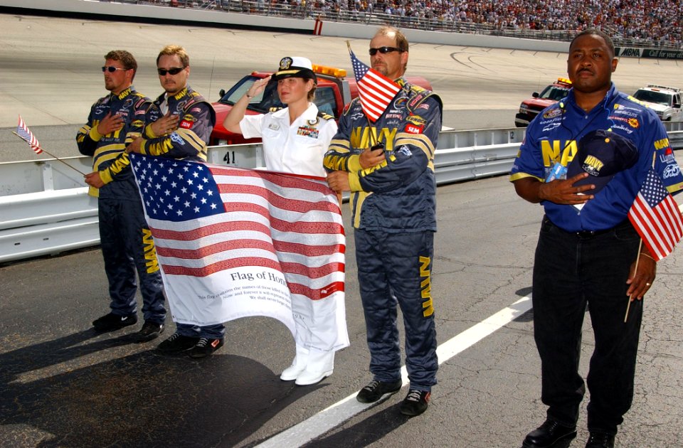 US Navy 040925-N-4729H-621 Lt. Heather Lichtenberg, center, Navy Career Counselor 1st Class Carlos Andrews, far right, and members of the Navy NASCAR pit crew stand in formation