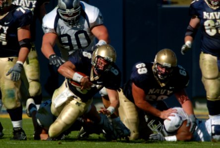 US Navy 041023-N-9693M-002 U.S. Naval Academy Quarterback Midshipman 1st Class Aaron Polanco is tackled after rushing for yardage in the first quarter of play against the Rice Owls