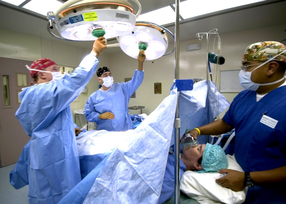 US Navy 040907-N-5134H-001 Hospital Corpsman Second Class Eric Tooneo, right, and Hospitalman Matt Winchester, left, place sterile covers over the light handles