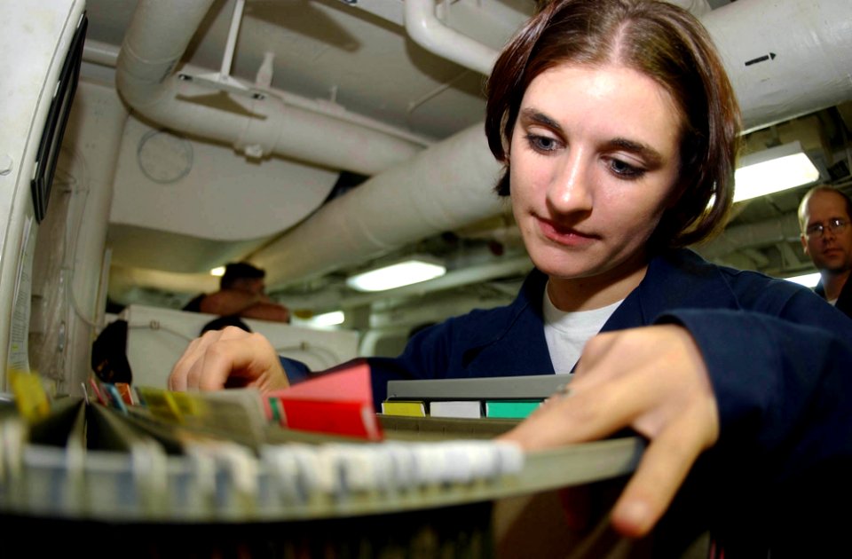US Navy 041007-N-8158F-039 Personnelman Christina Embleton of San Francisco, Calif., searches through personnel service records to update vital information for over 3,000 personnel aboard the aircraft carrier USS Nimitz (CVN 68
