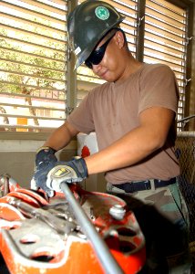 US Navy 040927-N-3019M-002 Engineering Aide 2nd Class Richard Vilar, assigned to Naval Construction Battalion Unit Four One Three (CBU-413), cuts electrical piping for a new wall