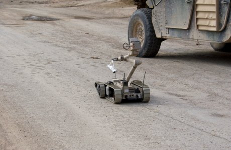 US Navy 041103-N-4614W-040 A U.S. Army explosive ordnance disposal (EOD) robot, i-Robot carries a stick of C4 plastic explosives down the street to an alleged improvised explosive device (IED), found by the Iraqi Police photo