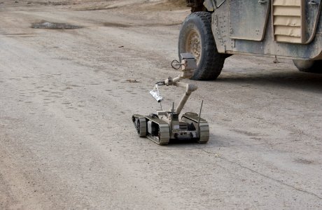 US Navy 041103-N-4614W-040 A U.S. Army explosive ordnance disposal (EOD) robot, i-Robot carries a stick of C4 plastic explosives down the street to an alleged improvised explosive device (IED), found by the Iraqi Police