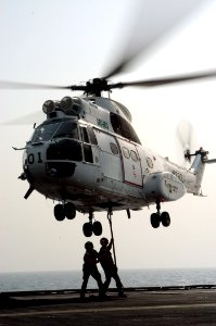 US Navy 040817-N-8704K-003 Aviation Ordnanceman aboard the aircraft carrier USS John F. Kennedy (CV 67) attach a cargo pennant to a SA-332 Super Puma helicopter from the combat stores ship USNS Spica (T-AFS 9) during a replenis