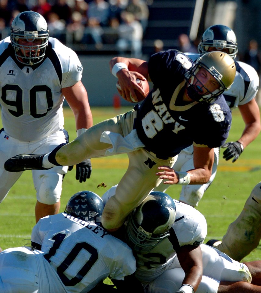 US Navy 041023-N-9693M-006 U.S. Naval Academy Quarterback Midshipman 1st Class Aaron Polanco is tackled during a rushing attempt in the third quarter of play against the Rice Owls