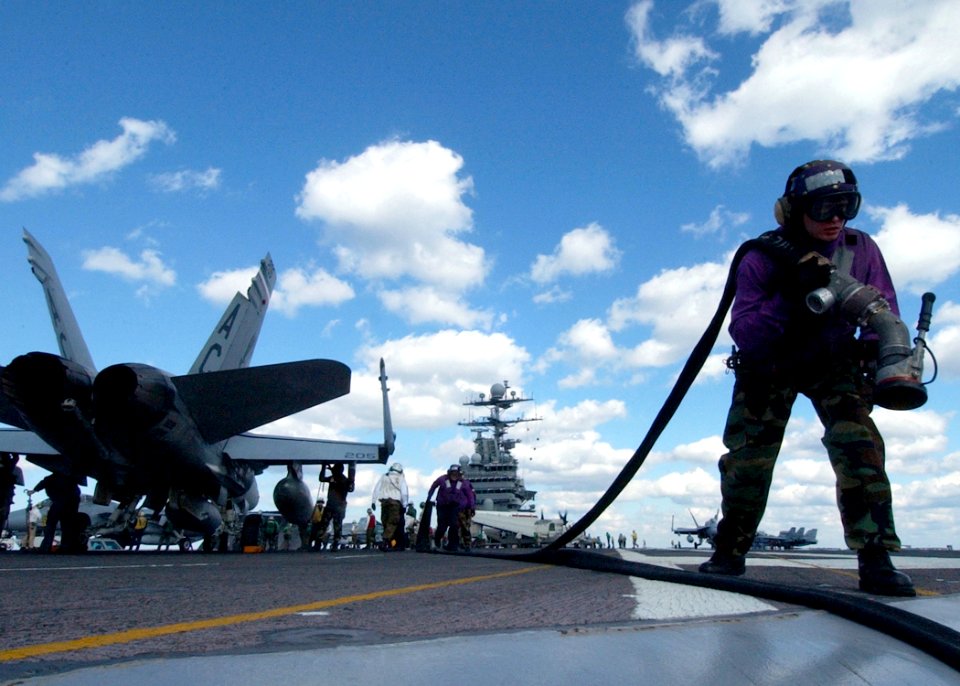 US Navy 041015-N-4308O-015 Airman Travis Vangundy pulls a fuel hose across the flight deck aboard the Nimitz-class aircraft carrier USS Harry S. Truman (CVN 75)