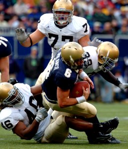 US Navy 041016-N-9693M-019 U.S. Naval Academy Midshipman Quarterback Aaron Polanco is tackled by Notre Dame line backer Corey Mays at Giants Stadium in East Rutherford, N.J photo