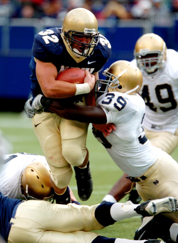 US Navy 041016-N-9693M-004 U.S. Naval Academy Midshipman 1st Class Kyle Eckel is tackled by Notre Dame line backer Brandon Hoyte at Giants Stadium in Rutherford, N.J
