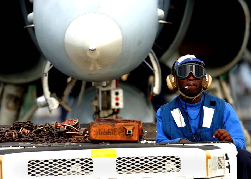 US Navy 041115-N-5345W-020 Airman Ozell Venning tows an F-A-18C Hornet assigned to the Bulls of Strike Fighter Squadron Three Seven (VFA-37) toward the waist catapults aboard USS Harry S. Truman (CVN 75), prior to the commence