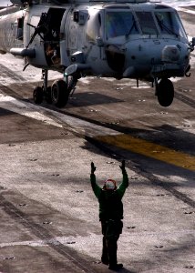 US Navy 041119-N-5345W-014 A Landing Signal Enlisted (LSE) communicates with the pilot of an HH-60H Seahawk helicopter via hand signals