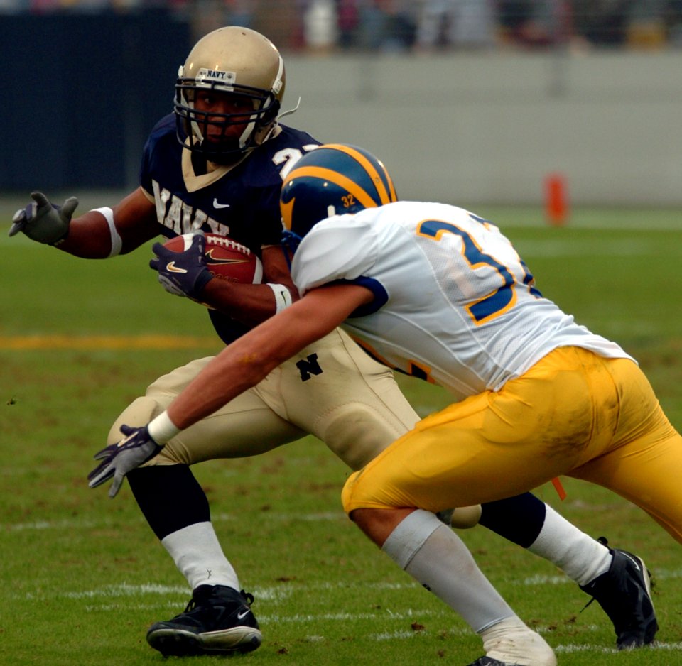 US Navy 041030-N-9693M-026 Delaware Blue Hen's defensive back Kyle Campbell tries to block U.S. Naval Academy Midshipman 3rd Class Trey Hines on a rushing attempt in the 2nd quarter of play