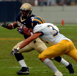 US Navy 041030-N-9693M-026 Delaware Blue Hen's defensive back Kyle Campbell tries to block U.S. Naval Academy Midshipman 3rd Class Trey Hines on a rushing attempt in the 2nd quarter of play